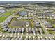 Wide aerial shot showcases a community with multiple homes surrounding a central lake, highlighting the neighborhood layout at 10112 Canaveral Cir, Sarasota, FL 34241