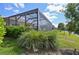 Lush backyard view showing the home, pond, and mature trees from the lawn at 10112 Canaveral Cir, Sarasota, FL 34241