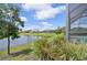 Water view backyard with screen enclosed porch and lush green landscaping at 10112 Canaveral Cir, Sarasota, FL 34241
