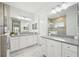 Bathroom features double vanity with granite countertop and modern white cabinets at 10112 Canaveral Cir, Sarasota, FL 34241