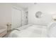 Bedroom with a closet and a mirror on the wall, featuring a bed and sitting chair at 10112 Canaveral Cir, Sarasota, FL 34241