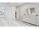 Bright bedroom featuring a white dresser with decorative mirror and ensuite bathroom at 10112 Canaveral Cir, Sarasota, FL 34241