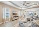 Open-concept living room with hardwood flooring, comfortable seating, tray ceilings, and backyard views at 10112 Canaveral Cir, Sarasota, FL 34241