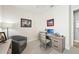 Office space with desk, chair, and artwork, featuring a lamp and a grey armchair at 10112 Canaveral Cir, Sarasota, FL 34241
