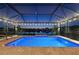 Screened-in backyard pool with lake view, perfect for relaxation and entertaining, under romantic string lights at 10112 Canaveral Cir, Sarasota, FL 34241
