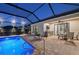 Beautiful screened-in pool with brick patio, outdoor kitchen, and space for dining and relaxing at 10112 Canaveral Cir, Sarasota, FL 34241