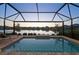 Private screened pool overlooking a serene lake, perfect for relaxation at 10112 Canaveral Cir, Sarasota, FL 34241