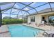 Screened-in pool area with patio, chairs, and view of backyard at 10112 Canaveral Cir, Sarasota, FL 34241