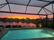 Stunning sunset view from the private screened-in pool overlooking the tranquil water at 10112 Canaveral Cir, Sarasota, FL 34241