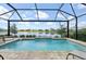 This pool has a tranquil lake view framed by a screen enclosure with lounging chairs at 10112 Canaveral Cir, Sarasota, FL 34241