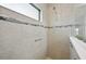 Close up of glass-enclosed shower with neutral tile and decorative band at 10112 Canaveral Cir, Sarasota, FL 34241