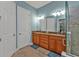 This primary bathroom offers a double vanity with granite counters and a tiled shower at 13096 N Marsh Dr, Port Charlotte, FL 33953