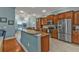 Open kitchen with a breakfast bar, granite countertops, stainless steel appliances, and custom wood cabinets at 13096 N Marsh Dr, Port Charlotte, FL 33953