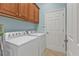 A laundry room featuring a washer, dryer, and overhead cabinets at 13096 N Marsh Dr, Port Charlotte, FL 33953