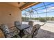 The screened-in patio features lovely furniture and views of the lake and pool at 13096 N Marsh Dr, Port Charlotte, FL 33953