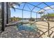 View of screened-in pool with brick patio and lake beyond at 13096 N Marsh Dr, Port Charlotte, FL 33953
