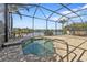 The screened-in pool features a brick patio and lovely lake views at 13096 N Marsh Dr, Port Charlotte, FL 33953