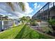 Well-manicured lawn and landscaping lead to the boat dock and canal from the screened pool at 1336 Casey Key Dr, Punta Gorda, FL 33950