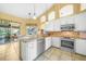 Modern kitchen with white cabinets, stainless steel appliances, and granite countertops with bar seating at 1336 Casey Key Dr, Punta Gorda, FL 33950