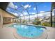 A view of the screened-in pool with dolphin mosaic, overlooking a canal under a blue sky at 1336 Casey Key Dr, Punta Gorda, FL 33950