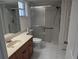 Bathroom featuring single sink vanity, toilet, white tile floor, and walk-in shower with sliding door at 1340 San Cristobal Ave # 207, Punta Gorda, FL 33983