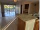 Spacious kitchen featuring a tiled floor, a breakfast bar and a view from sliding doors of a patio and golf course at 1340 San Cristobal Ave # 207, Punta Gorda, FL 33983