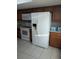 Kitchen featuring a white stove and microwave, next to brown cabinets and a large white refrigerator at 1340 San Cristobal Ave # 207, Punta Gorda, FL 33983