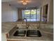 Open kitchen with double sinks and granite counters overlooking the living area at 1340 San Cristobal Ave # 207, Punta Gorda, FL 33983