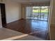 Bright living room featuring wood floors that transition into a tile kitchen area and a sliding door to outdoor seating at 1340 San Cristobal Ave # 207, Punta Gorda, FL 33983