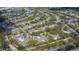 This aerial view showcases the property's placement in a quiet, tree-lined neighborhood with a nearby lake at 1355 Red Oak Ln, Port Charlotte, FL 33948