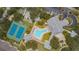 An aerial view showcasing a community pool, tennis courts, shuffleboard, clubhouse, and parking lot at 1355 Red Oak Ln, Port Charlotte, FL 33948
