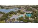 An aerial view of the community's clubhouse, pool, tennis courts, and lakefront apartments at 1355 Red Oak Ln, Port Charlotte, FL 33948