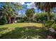 Expansive backyard featuring tropical landscaping and a screened-in porch, perfect for relaxation and entertainment at 1355 Red Oak Ln, Port Charlotte, FL 33948
