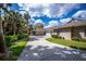 Beautiful driveway leads to a home with a large garage surrounded by tropical landscaping at 1355 Red Oak Ln, Port Charlotte, FL 33948