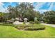 Welcoming entrance to Heritage Oak Park with manicured landscaping and an American flag at 1355 Red Oak Ln, Port Charlotte, FL 33948