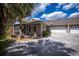 Charming entrance featuring a covered porch, detailed front door, and a lush, landscaped garden at 1355 Red Oak Ln, Port Charlotte, FL 33948