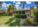 Charming home with lush tropical landscaping, screened porch, and manicured lawn on a sunny day at 1355 Red Oak Ln, Port Charlotte, FL 33948