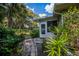 Exterior view of the property's screened porch and lush, tropical landscaping with a stone pathway at 1355 Red Oak Ln, Port Charlotte, FL 33948