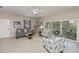 Bright living room with comfortable seating and sliding glass doors to a screened patio at 1355 Red Oak Ln, Port Charlotte, FL 33948