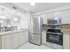 Updated kitchen showcasing stainless steel appliances, granite countertops, and white cabinetry at 1356 Rio De Janeiro Ave # 107, Punta Gorda, FL 33983