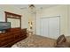 Cozy bedroom featuring dark wood furniture, ceiling fan, and double door closet at 1474 Red Oak Ln, Port Charlotte, FL 33948