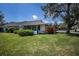 Charming home exterior featuring lush landscaping and a screened lanai for outdoor relaxation at 1474 Red Oak Ln, Port Charlotte, FL 33948