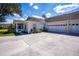 View of the side of the home showing large driveway, two-car garage, and enclosed porch at 1474 Red Oak Ln, Port Charlotte, FL 33948