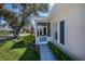Charming front entrance with a screened-in porch and manicured landscaping at 1474 Red Oak Ln, Port Charlotte, FL 33948