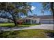 Charming home featuring a lush landscaped front yard with a welcoming two-car garage at 1474 Red Oak Ln, Port Charlotte, FL 33948