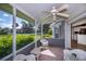 Screened lanai with seating, ceiling fan and view of the landscaped outdoors at 1474 Red Oak Ln, Port Charlotte, FL 33948