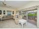 Bright living room with tile floors, ceiling fan, and sliding glass doors to the screened lanai at 1474 Red Oak Ln, Port Charlotte, FL 33948