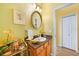 Bright bathroom featuring a round mirror, stylish vanity, and a charming decorative display shelf at 16531 San Edmundo Rd, Punta Gorda, FL 33955