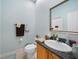 Cozy half bath with wood cabinets, granite counters, and decorative mirror at 16531 San Edmundo Rd, Punta Gorda, FL 33955