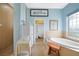 Bright bathroom with large tub, tiled shower, blue walls, and glass block window at 16531 San Edmundo Rd, Punta Gorda, FL 33955